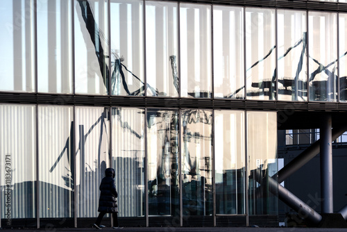 Harbor cranes reflecting in glass façade of modern building at the Elbe River in Hamburg