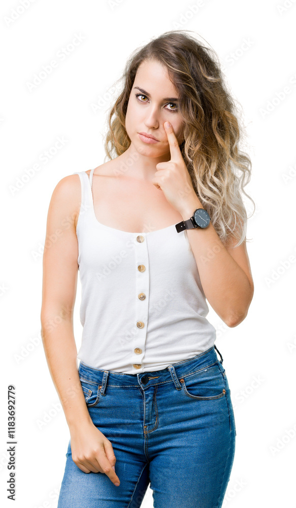 Fototapeta premium Beautiful young blonde woman over isolated background Pointing to the eye watching you gesture, suspicious expression