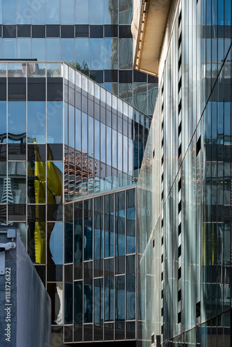 This photograph showcases various reflective surfaces of modern buildings, creating a chaotic yet beautiful visual mix, highlighting the dynamic nature of urban architecture.