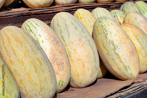 Obraz na płótnie Vibrant display of fresh melons at a bustling local market in summer sun w salonie