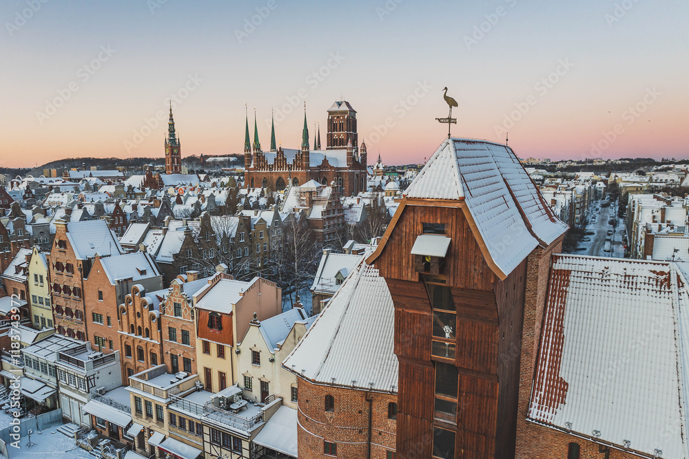 Gdańsk with a view of the Crane in the winter morning. Snow on the roofs of tenement houses and streets.