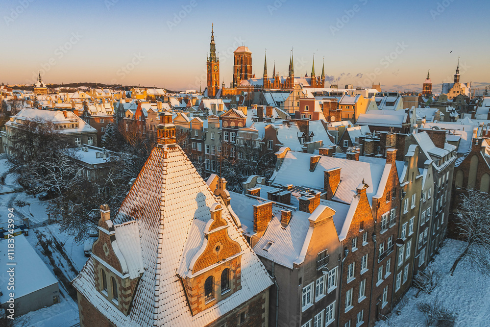 Gdańsk with a view of St. Mary's Basilica in the winter morning. Snow on the roofs of tenement houses and streets.