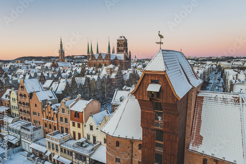 Obraz na płótnie
Gdańsk with a view of the Crane in the winter morning. Snow on the roofs of tenement houses and streets. w salonie