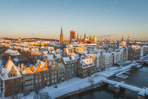 Gdańsk with a view of the Motława River in the morning in winter. Snow on the roofs of tenement houses and streets. photo