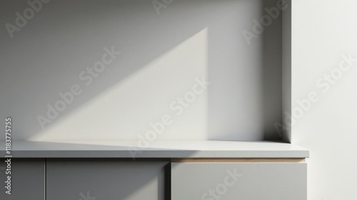Minimalist grey countertop with sunlight shadows on a neutral wall