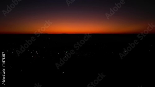 Timelapse of sunlight fading out into darkness, while the town's flickering lights are getting stronger photo