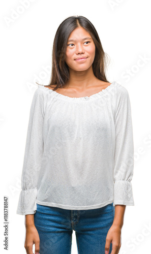 Young asian woman over isolated background smiling looking side and staring away thinking.