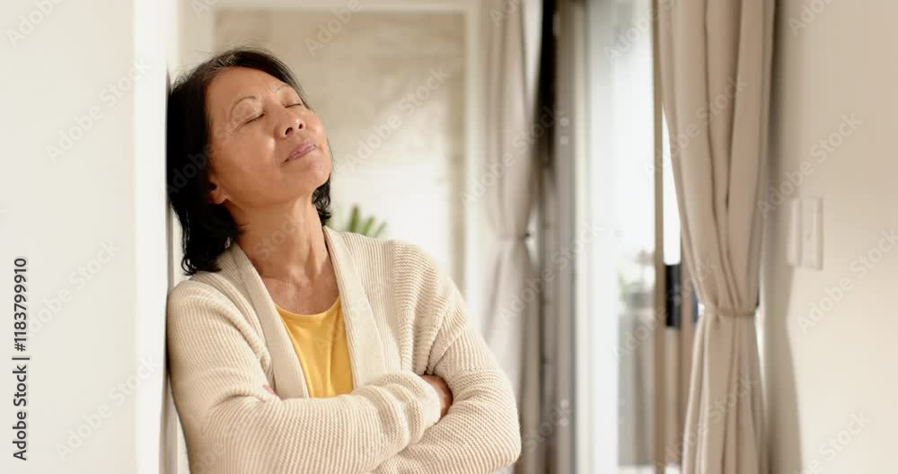 Senior Asian woman relaxing at home, smiling peacefully with eyes closed, copy space Senior Asian woman relaxing at home, smiling peacefully with eyes closed, copy space