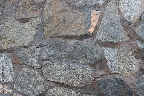 Close view of wall made of gray natural shape fieldstones photo