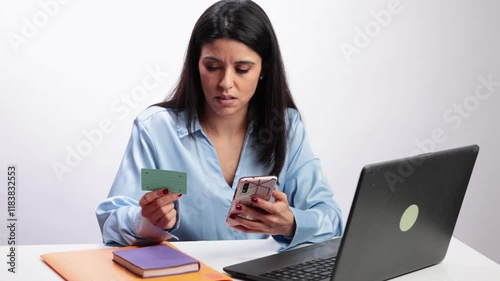 Latin woman paying online with credit card and smartphone in slow motion