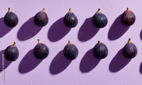 Artistic Arrangement of Purple Figs Against a Pastel Lavender Background photo