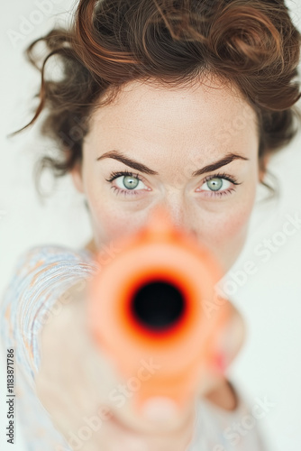 woman with a playful expression points a toy gun at the camera, showcasing confidence and fun.advertising, social media content, lifestyle campaigns, fun promotional material, fashion shoots, playful  photo