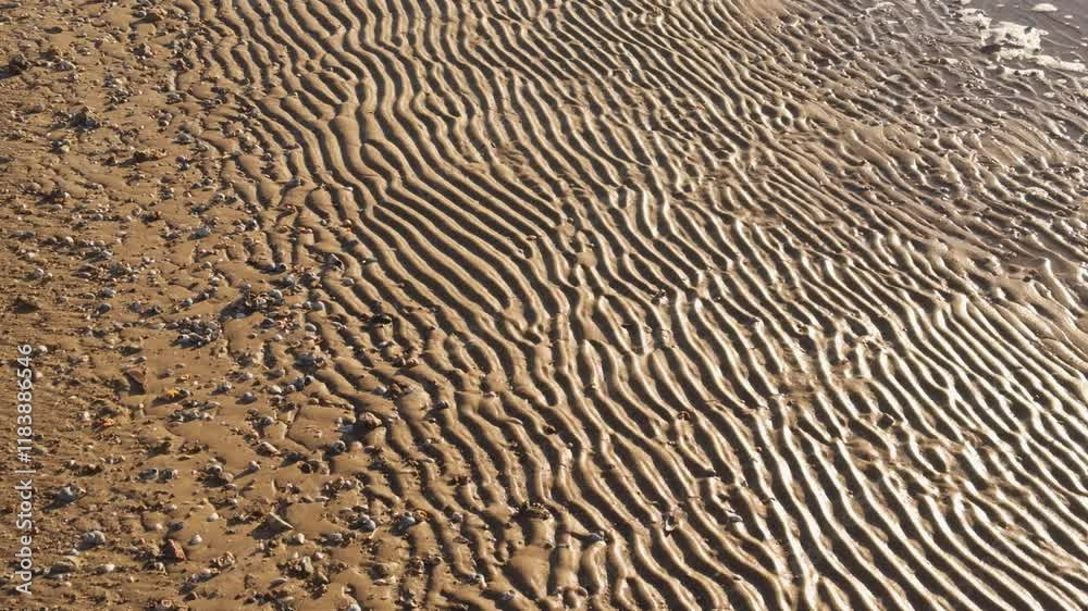 Wavy pattern on sand left by waves at low tide. Wavy pattern on sand left by waves at low tide.
