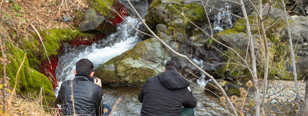 Obraz premium Photographer holding a digital camera taking pictures in nature.