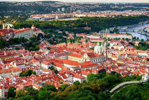 A stunning aerial view of a picturesque European city with charming red-roofed buildings, a winding river, and a vibrant green park, ideal for travel enthusiasts seeking adventure and culture. photo