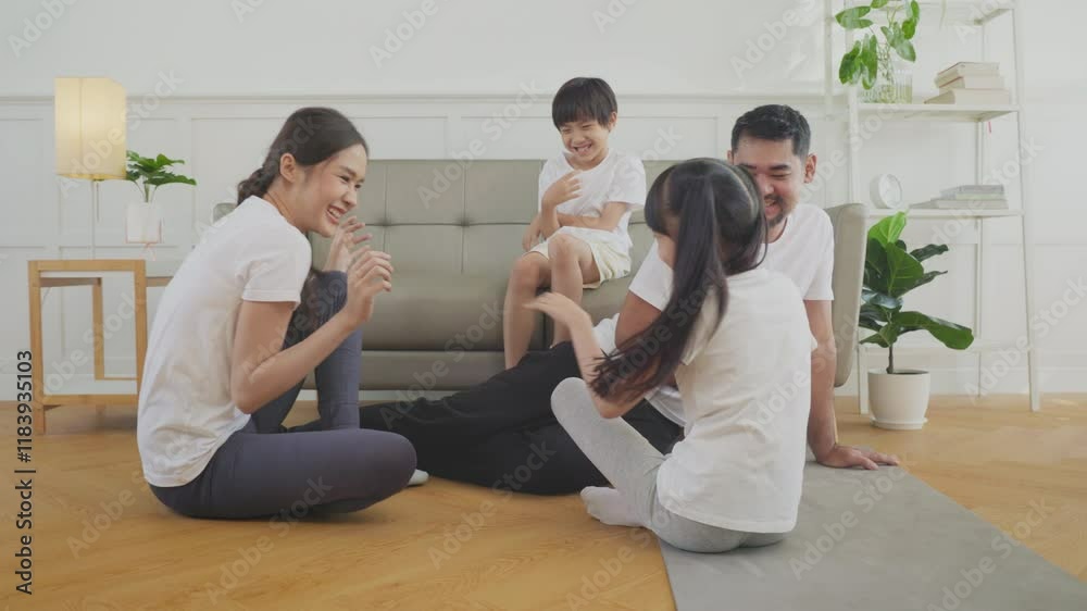 Young asian father and mother and her children practicing yoga at home. Young asian father and mother and her children practicing yoga at home.