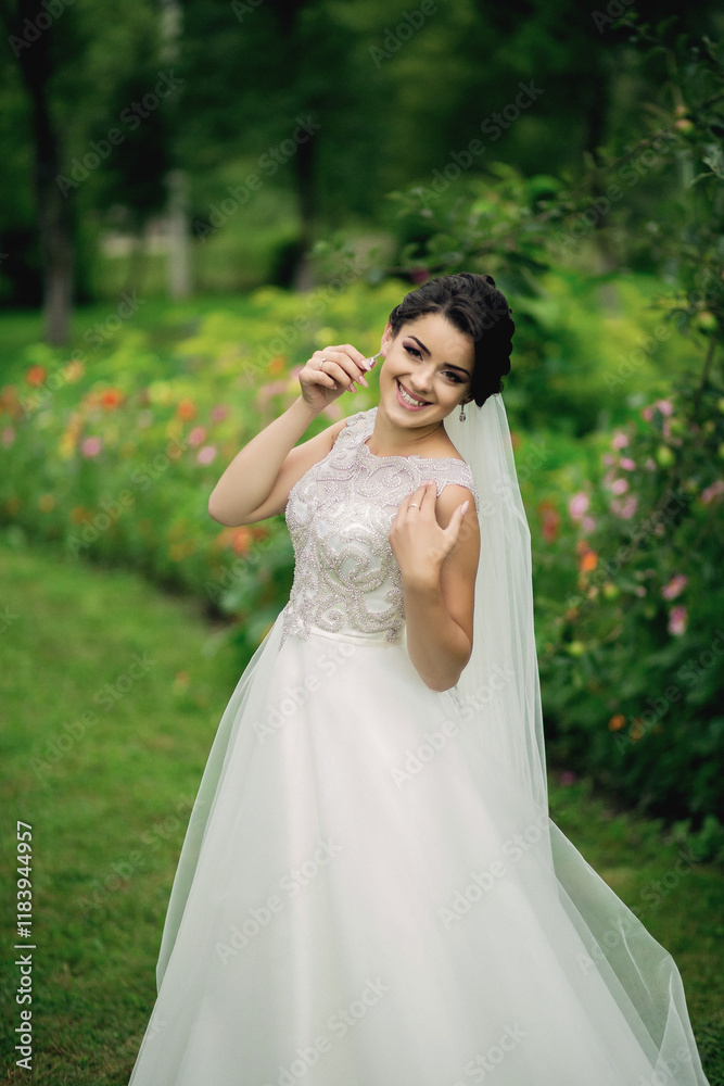 A woman in a white dress is posing for a picture in a field of flowers. She is smiling and she is happy A woman in a white dress is posing for a picture in a field of flowers. She is smiling and she is happy