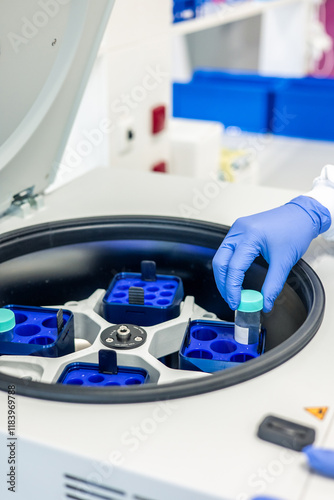 Scientist placing sample in laboratory centrifuge for testing 