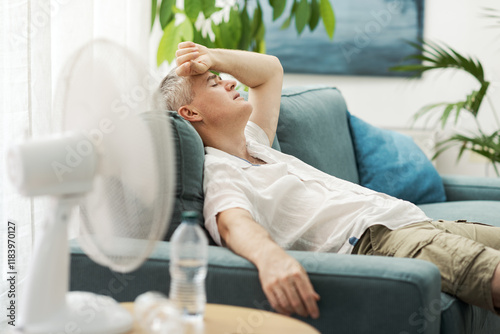 Tired man on the couch suffering from the heat