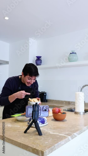 Vertical video of cheerful young man showing ingredients in a tutorial on how to cook a dessert at home, homemade food