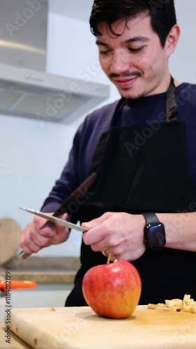 Vertical video of man sharpening knives to cut some apples on wooden board to make dessert, homemade food