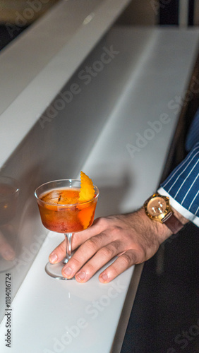 Transparent cocktail in a bar in a man's hand
