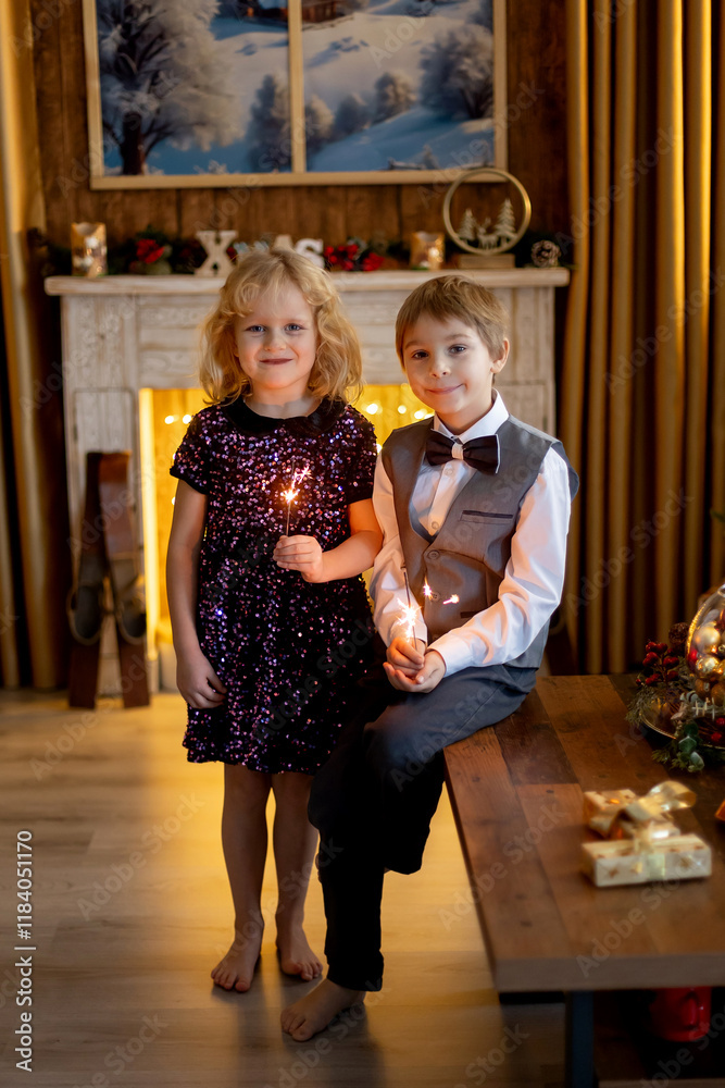 Φωτογραφία Brother and sister, children on christmas, holding sparklers in front of the Chr