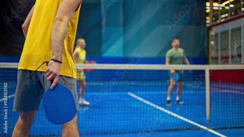 Wallpaper Mural Two men and two women playing pickleball on a blue, inside court Torontodigital.ca