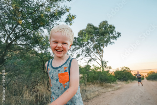 Happy boy smiling on bushwalk along rural Australian country road