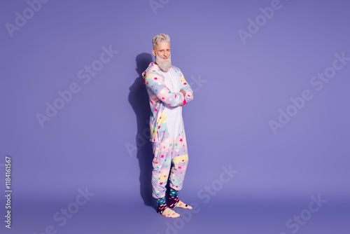 Trendy mature man in unicorn pajama ready to embrace the day with a smile against vibrant purple backdrop photo