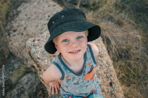 Little boy sitting on granite rock on an outing in the Australian bush