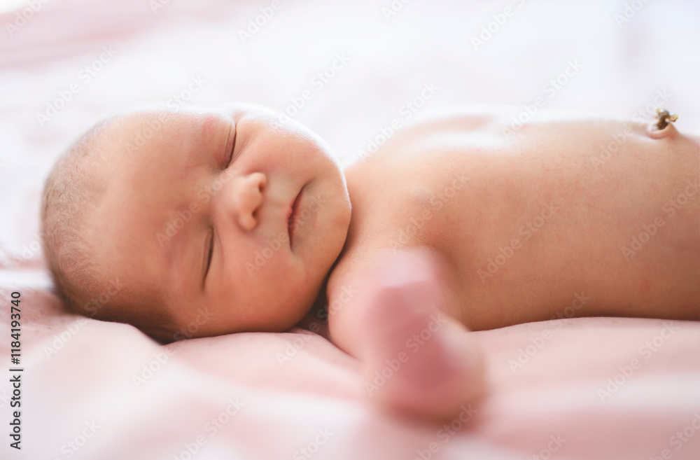Adorable baby in pink sunny bedroom. Newborn child relaxing in bed. Adorable baby in pink sunny bedroom. Newborn child relaxing in bed.