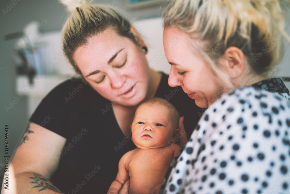 Women gay couple having fun with their baby daughter at home. Women gay couple having fun with their baby daughter at home.