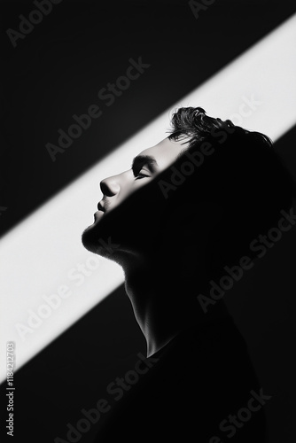 Minimalistic design concept. Arty, graphic profile portrait of a young man posing on black and white background. Monochrome vertical studio shot photo
