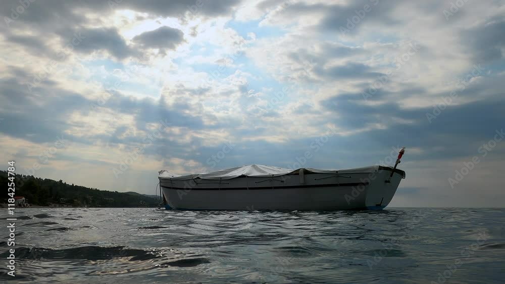 A serene snapshot captures a single boat gently floating atop a still, deep blue sea under a broad, clear sky, epitomizing tranquility and solitude in nature's expanse. A serene snapshot captures a single boat gently floating atop a still, deep blue sea under a broad, clear sky, epitomizing tranquility and solitude in nature's expanse.