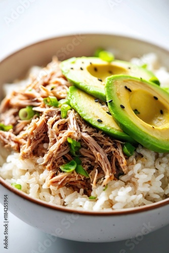 Tender shredded meat atop fluffy rice, garnished with fresh avoc photo