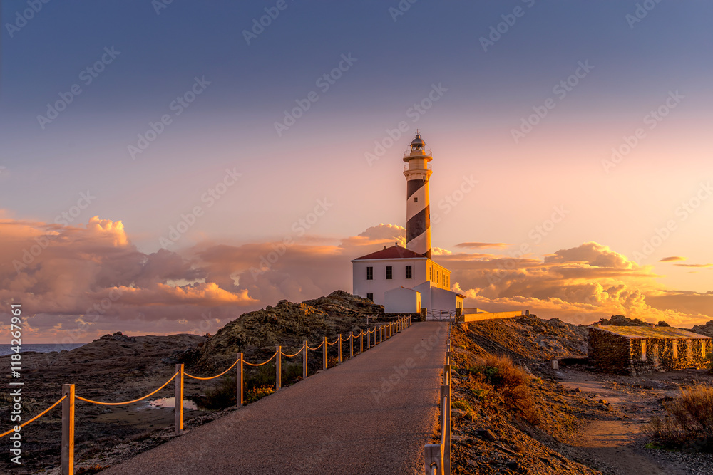 Morning light at the Favaritx Lighthouse, perched on a rugged coastline near Mahon, Menorca, in the Balearic Islands of Spain, offering breathtaking views of the Mediterranean Sea