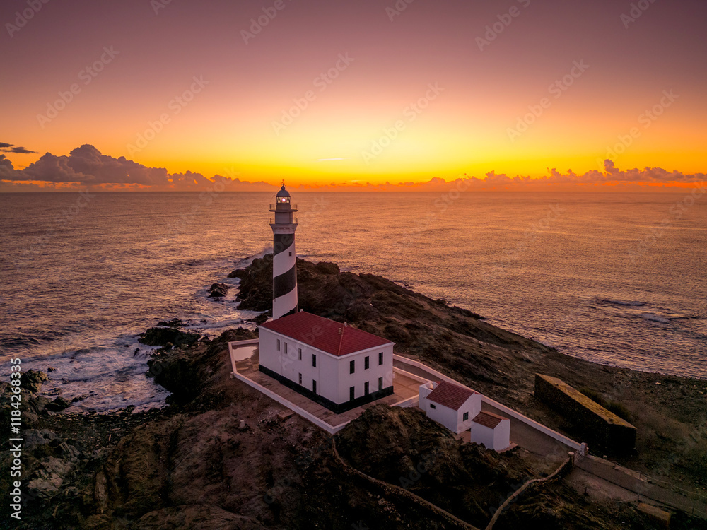 First light at the Favaritx Lighthouse, located near Mahon in Menorca, Balearic Islands, Spain, highlighting the lighthouse's striking silhouette against the morning sky