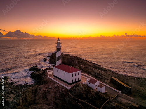 Obraz na płótnie First light at the Favaritx Lighthouse, located near Mahon in Menorca, Balearic Islands, Spain, highlighting the lighthouse's striking silhouette against the morning sky w salonie