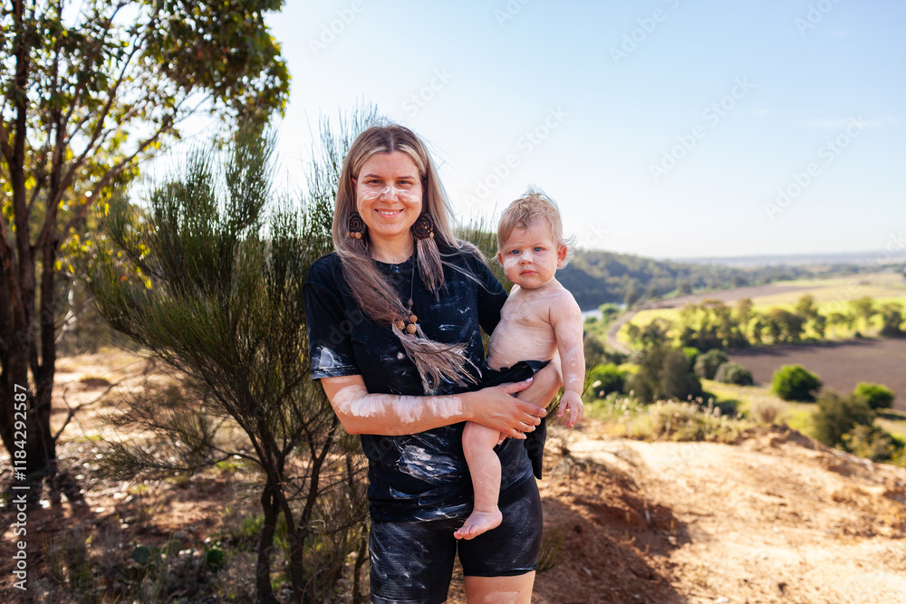 Aboriginal mum with her baby boy together by cliff on country in Australian bushland Aboriginal mum with her baby boy together by cliff on country in Australian bushland