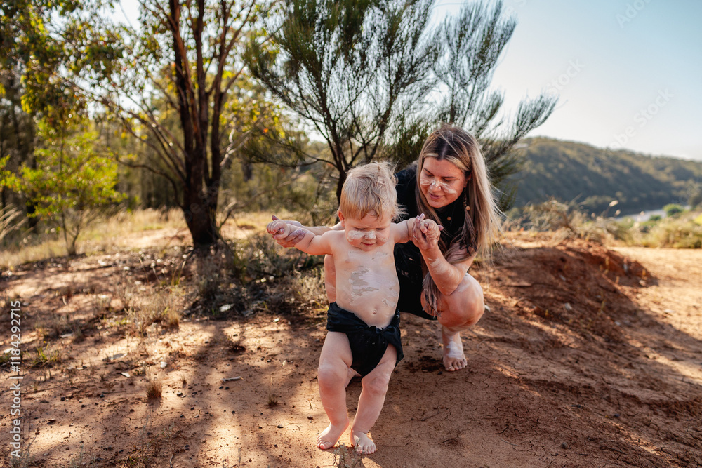 Aboriginal mum with her baby boy together by cliff on country in Australian bushland Aboriginal mum with her baby boy together by cliff on country in Australian bushland