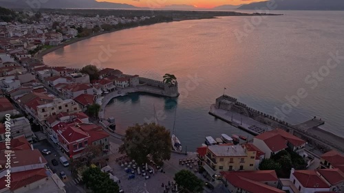 Aerial view of nafpaktos venetian port at sunrise with beautiful coastal town and scenic mountains, Nafpaktos, Greece. photo