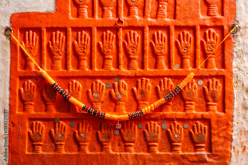 Wand mit orangenen Händen an der Münzen kleben für Glück und eine Kette aus Blumen Mehrangarh Festungsanlage in Jodhpur Rajasthan Indien photo