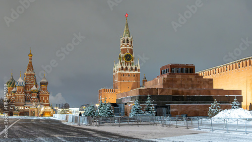 The Kremlin wall in winter in Moscow. St. Basil's Cathedral and the mausoleum next to the Kremlin on Red Square. The Kremlin wall is illuminated by lanterns at night. The Spasskaya tower with chimes.