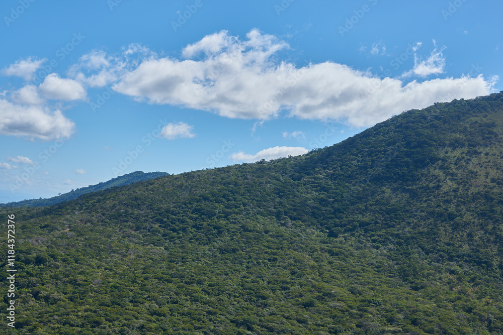 huge green mountain with blue sky background and white clouds huge green mountain with blue sky background and white clouds