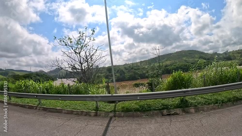 Car ride along the road on a sunny day with lots of clouds in the sky and intense car and truck traffic. During a holiday.