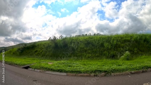 Car ride along the road on a sunny day with lots of clouds in the sky and intense car and truck traffic. During a holiday.