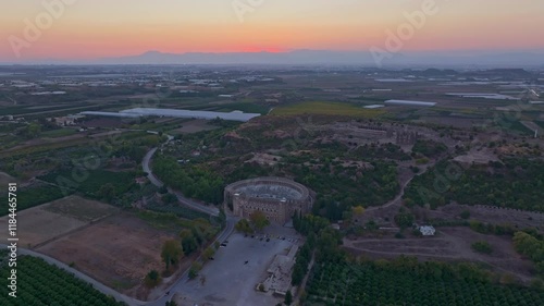 Aerial view of Aspendos Theatre at sunset surrounded by tranquil fields and a serene landscape, Serik, Turkey. photo