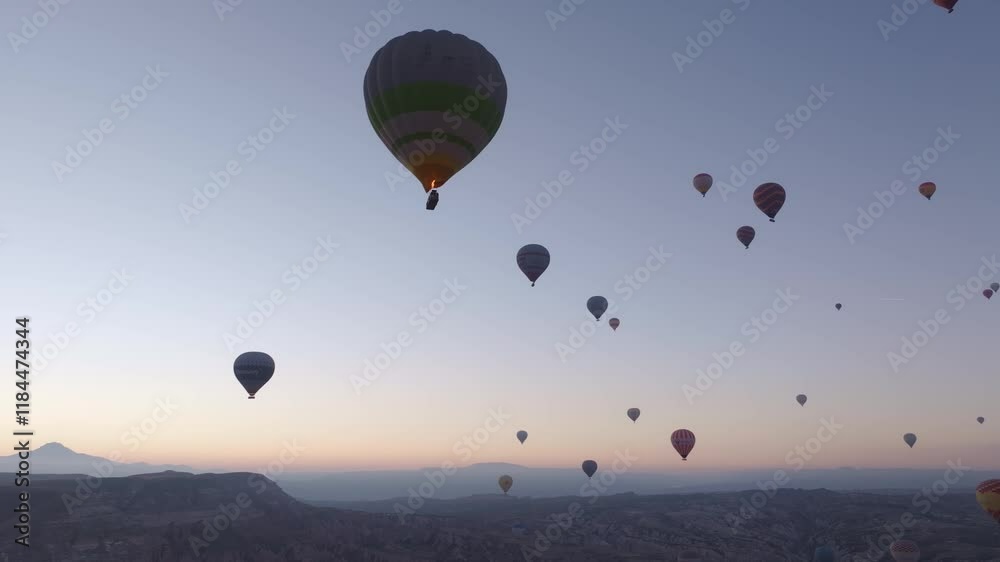 Aerial view of colorful hot air balloons floating over serene Rose Valley at sunrise, Goreme, Turkey. Aerial view of colorful hot air balloons floating over serene Rose Valley at sunrise, Goreme, Turkey.