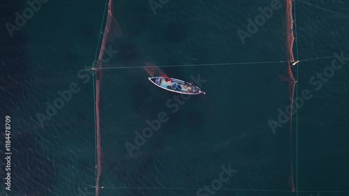 Aerial view of fishing boats and nets on a serene Aegean Sea at sunrise, Epanomi, Greece. photo